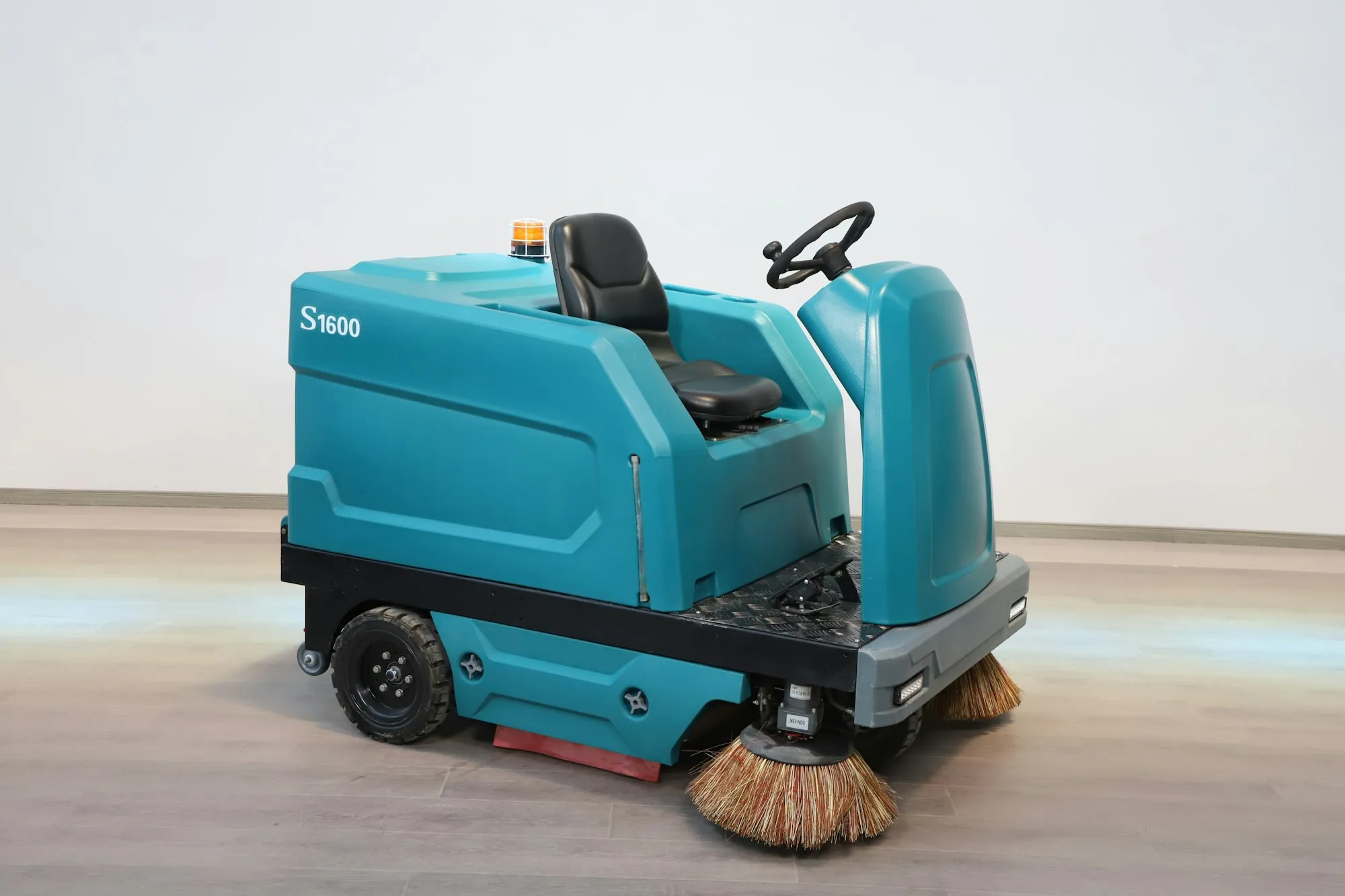 Commercial ride-on floor scrubber shown from the side