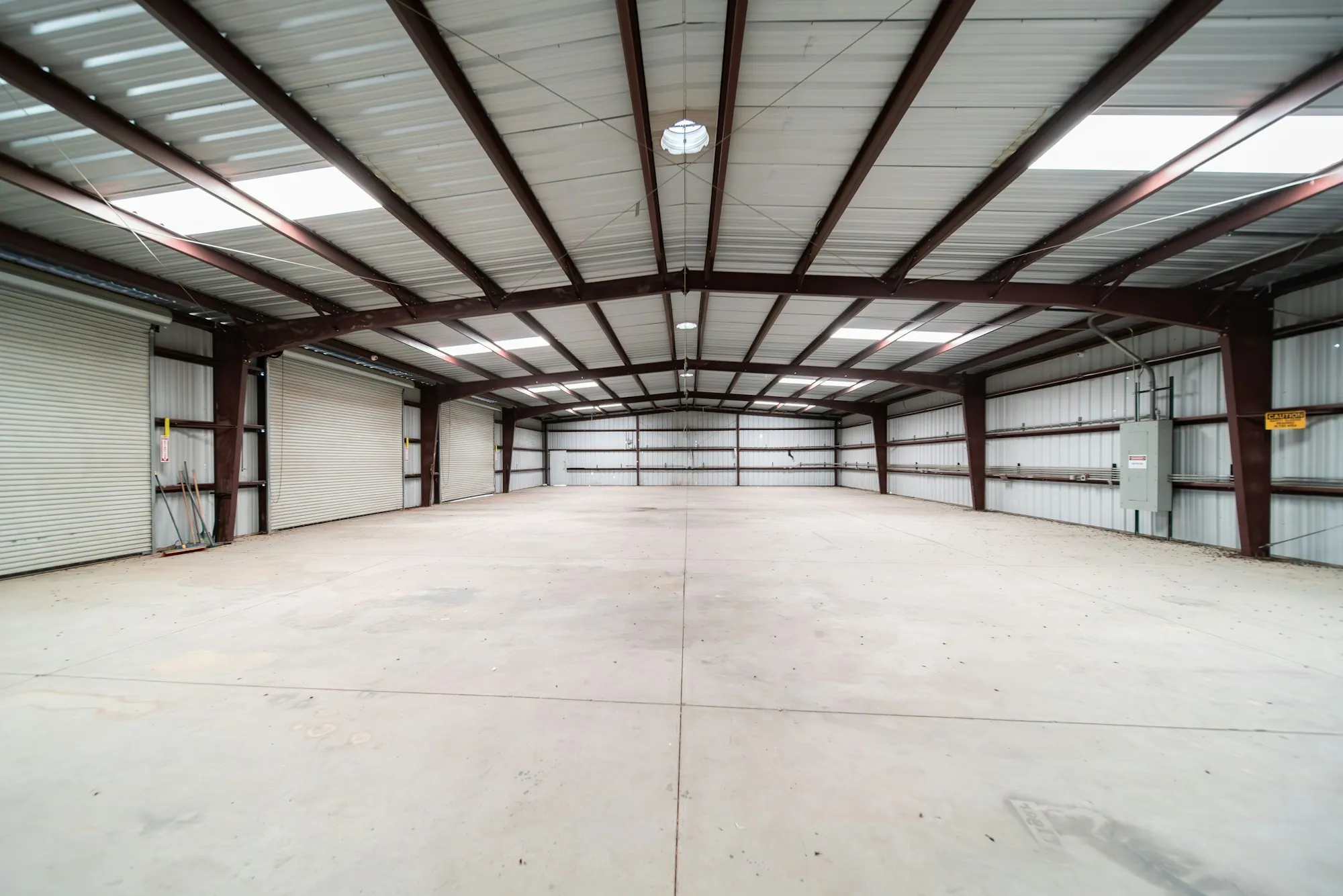 Empty steel-framed warehouse with a concrete floor